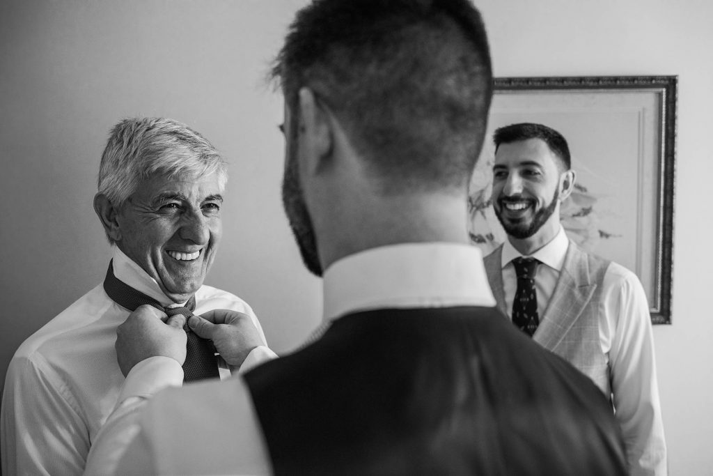 fotografo de boda del novio ayuda al padre